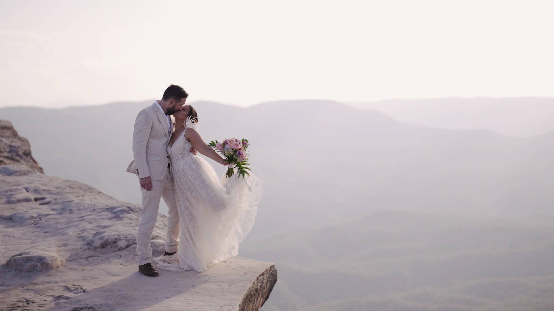 Newly married standing on a cliff with views of a valley - wedding videography services in the Blue Mountains and Greater NSW - Lovereel