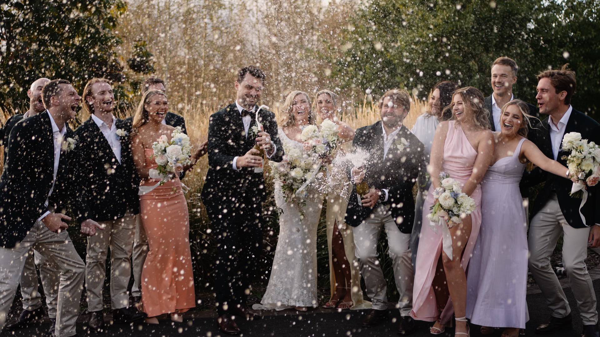 Bridal party celebrating by popping champagne bottles - photographer and wedding videographer Kangaroo Valley - Lovereel